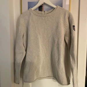  stickad tröja med dragkedja från Bondelid - Säljer en stilren beige stickad tröja från Bondelid. Tröjan har en dragkedja i nacken och ett snyggt märke på ärmen. Har en liten defekt brevid dragkedjan ( en liten fläck ) som syns med ett blott öga ( se sista bilden kr