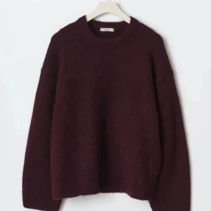 Vinröd stickad tröja - Säljer en mysig vinröd stickad tröja med rund hals och långa ärmar. Perfekt för kyliga dagar och ger en stilren look. Passar bra till både jeans och kjol.