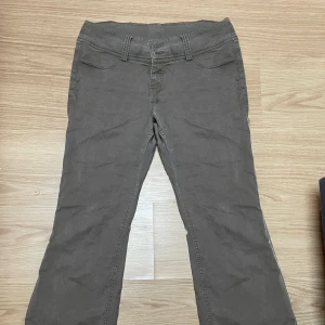 Bruna byxor från Weekday - Snygga bruna byxor från Weekday med bootcut-stil. De är midwaist och är tillverkade i ett bekvämt bomullsmaterial. Perfekta för en avslappnad look.