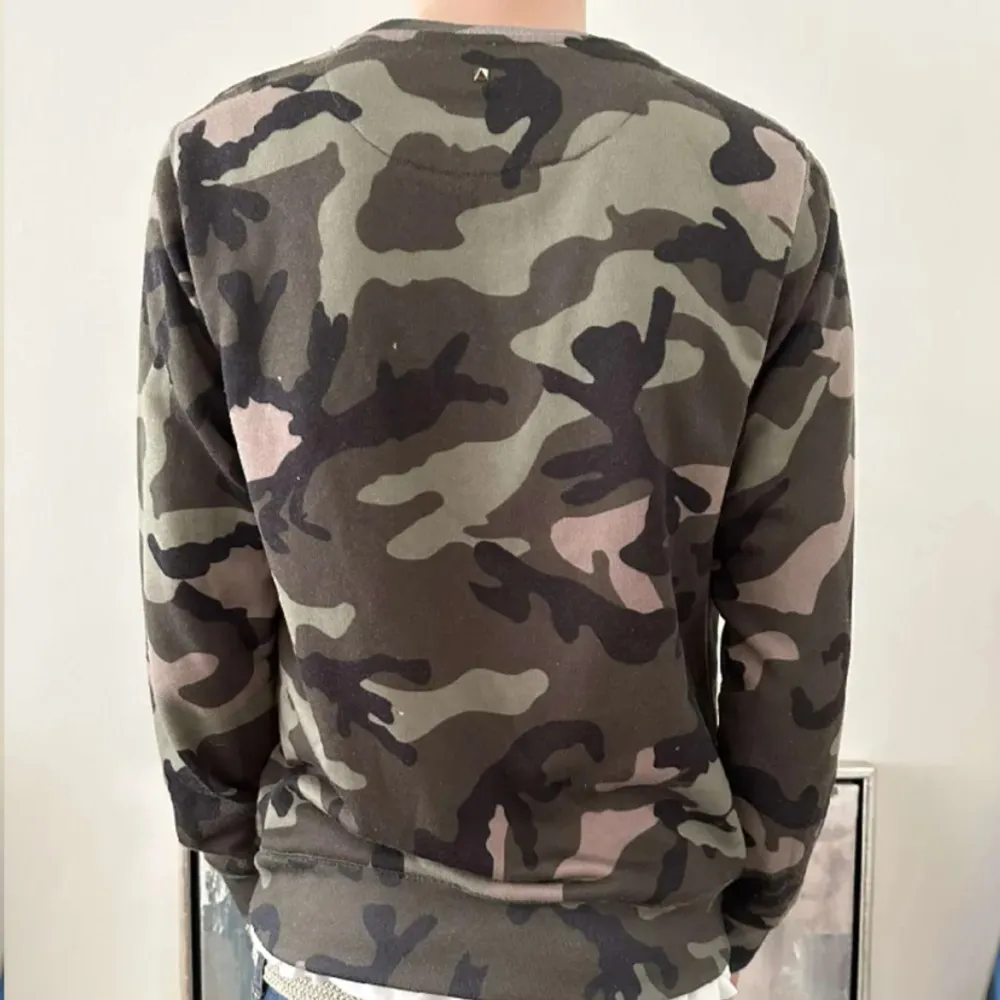Säljer en snygg camouflage tröja från Valentino. Tröjan har ett klassiskt mönster i gröna och bruna toner. Perfekt för en avslappnad stil.. Neuletakit & Villapaidat.