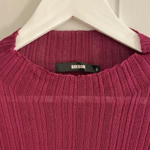 Vinröd topp - Bikbok - Vinröd topp från Bikbok, randigt/ribbat material något genomskinlig i materialet. Endast använd fåtal ggr så nästintill nyskick