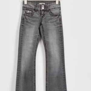 Low waisted jeans  - Jeans är från Gina Tricot. Tall jeans med låg midja. Jeansen är gråa och har utsvängda ben. De har låg stretch, två knappar framtill, fickor fram och bak och extra lång benlängd. Använda fåtal gånger förra året sedan dess så har de ej kommit till användning. 