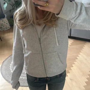 Grå hoodie med dragkedja - Säljer en grå hoodie med dragkedja och huva. Passar till allt och är bra för alla årstider🥰 Inga defekter som syns eller jag vet till! Pris kan självklart diskuterasn