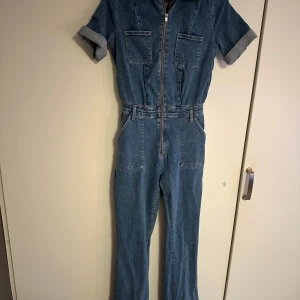 Jeans jumpsuit - Snygg jeans jumpsuit med korta ärmar och dragkedja framtill. Använd 2 ggr