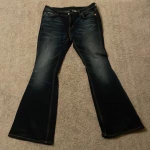 Mörkblå bootcut jeans från Weekday  - säljer fina low waisted jeans från weekday i modellen ”flame” använda några fåtal gånger och bara superlite slitna längst nere på benet, se bild. de passar mig som är runt 169 för referens! de har en jättefin blå färg! innerbensmått:74,5cm midjemått(rakt över midjan på byxorna):40cm