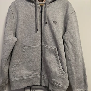Burberry zip Hoodie storlek L/XL - En grå burberry kofta som passar både storlek L och XL kan tänka mig att gå ner i pris vid en snabbaffär 