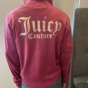 Rosa hoodie från Juicy Couture - Säljer en snygg rosa hoodie från Juicy Couture med glittrig logga på ryggen. Hoodien har dragkedja framtill och långa ärmar. Aldrig använd. Storlek 15 år, sitter bra på mig som har xs/s!