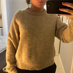 Beige stickad tröja från Carin Wester - Säljer en mysig beige stickad tröja från Carin Wester. Tröjan har en rund halsringning och långa ärmar, perfekt för kyligare dagar. Den är i storlek S och passar bra till både jeans och kjol. Ett måste i garderoben för en stilren look!
