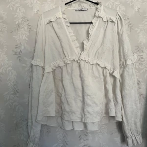 Vit NA-KD blus - Säljer nu denna vita NA-KD blus för den inte längre kommer till andvändning, den är super för och funkar lika bra till en middag som till vardags. Den är i storlek 34 och skulle även säga att den är sann i storleken❤️ skriv för mer frågor eller funderingar🥰 