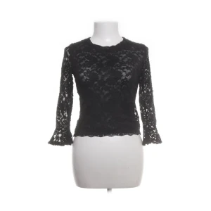Svart spetsblus från Bershka - Snygg svart spetsblus från Bershka. Blusen har en figurnära passform och är tillverkad i ett mjukt spetsmaterial. Skriv till mig om ni har frågor! 