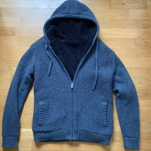 Grå fodrad cardigan   - Säljer en grå stickad cardigan med svart foder och huva. Perfekt för kyliga dagar! Mycket bra skick, storlek M men passar L. Pris 899 eller kom med bud! BVSA💰💰💰