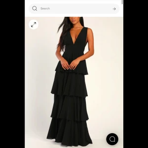 Balklänning med volanger - Supersnygg svart balklänning med v-ringning och  volanger från Lulus. Klänningen har en öppen rygg med en dragkedja och breda axelband. Säljer då jag köpt en annan🥰 Endast testad och köptes ny för 1450kr Skriv till mig innan ni köper! Jag är 172cm för referens och den går hela vägen till marken