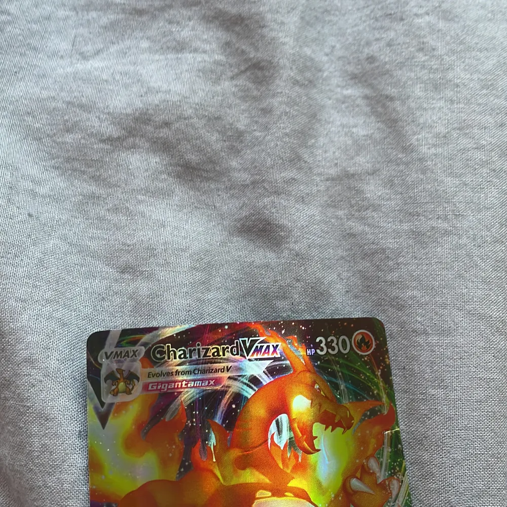 Säljer ett Charizard VMAX Pokémonkort med 330 HP. Kortet har en färgglad design med Charizard i fokus och inkluderar attacker som Claw Slash och G-Max Wildfire. Perfekt för samlare eller Pokémon-entusiaster! Obs igen frakt !. Asusteet.