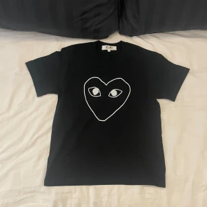 Cdg T-shirt - En riktig snygg T-shirt från Comme des Garçons. | Den passar som en vanlig T-shirt. Och personen på bilden är 170cm så den passar om man är där omkring i längden. | Det är bara att höra av sig om man har några frågor eller vill ha flera bilder🌄🌄🌄