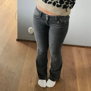 Super lågmdijade bootcut jeans  - Gråa väldigt lågmidjade bootcut jeans, men knappt som detaljer vid fickorna.  De är i storlek 24/30, passar mig som är 153 lång 