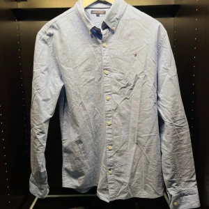 Tommy Hilfiger skjorta - Blå Tommy Hilfiger skjorta strl 176. Skick 9/10 knappt använd.