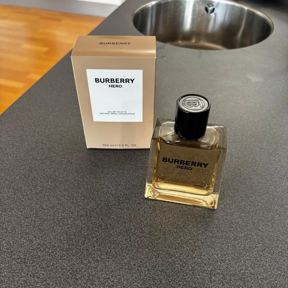 Säljer en elegant och stilren Burberry Hero Eau de Toilette. Flaskan rymmer 100 ml. Doften är fräsch och maskulin, perfekt för dagligt bruk eller speciella tillfällen. Kommer i en snygg beige kartong. Oanvänd, endast tagit ett sprut. Nypris: 1465 kr.. Parfym.