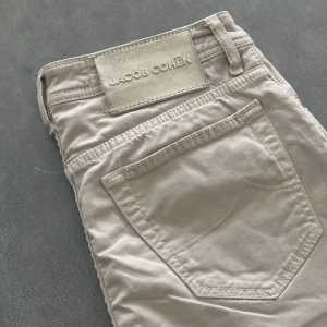 Jacob Cohen Jeans - Vita/beigea jeans från Jacob Cohen! Extremt bra skick, det ända är två ytterst små fläckar (bild 4, 5) Nypris runt 5000kr så säljer de för 1299kr. Hör av er!
