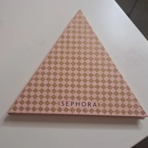 Ögonskuggspalett från Sephora - Säljer en superfin ögonskuggspalett från Sephora i en cool triangelform. Paletten har nio olika nyanser som är perfekta för att skapa både vardags- och festlooks. Färgerna varierar från neutrala toner till mörkare nyanser, vilket ger massor av möjligheter att experimentera med olika stilar. Perfekt för dig som älskar att leka med smink och vill ha en palett som är både snygg och praktisk!