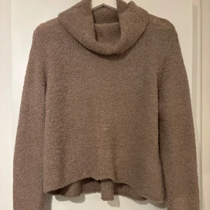 Stickad tröja  - Säljer denna supermysiga och fina stickade tröja med hög krage. Tröjan är lite kortare i modelln,  armarna är långa och har hål för tummarna. 