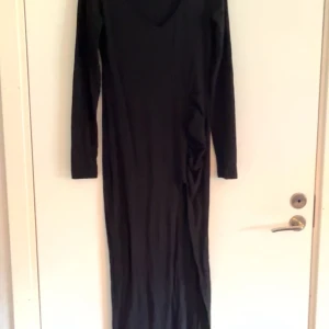 Svart klänning med slits - Bra skick, använd fåtal gånger efter som att den varit för lång. En jätte fin klänning men passar inte mig. den har en slits och ganska stretchigt tyg