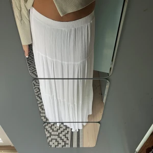 Lång volangkjol - Vit lång volangkjol från strandivarius, slutsåld från Zalando. Slutar precis vid fötterna på mig som är 173! Använd ett fåtal gånger 