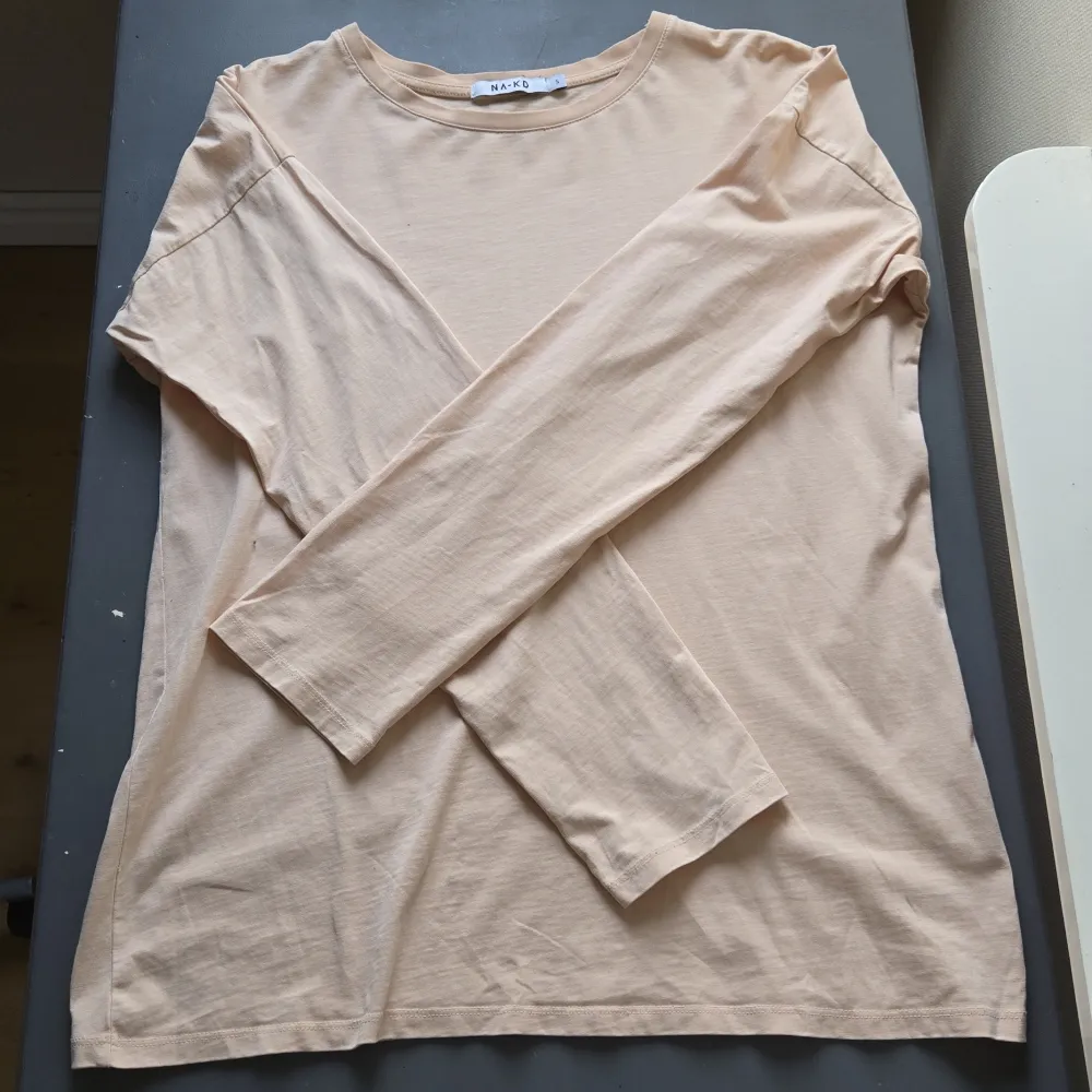 Säljer en superfin beige långärmad topp från NA-KD. Den är i storlek S och gjord av 100% bomull, vilket gör den riktigt skön och bekväm att ha på sig. Perfekt för både vardag och lite mer avslappnade tillfällen. Toppen är i nyskick och har en enkel, stilren design.. Tröjor & Koftor.