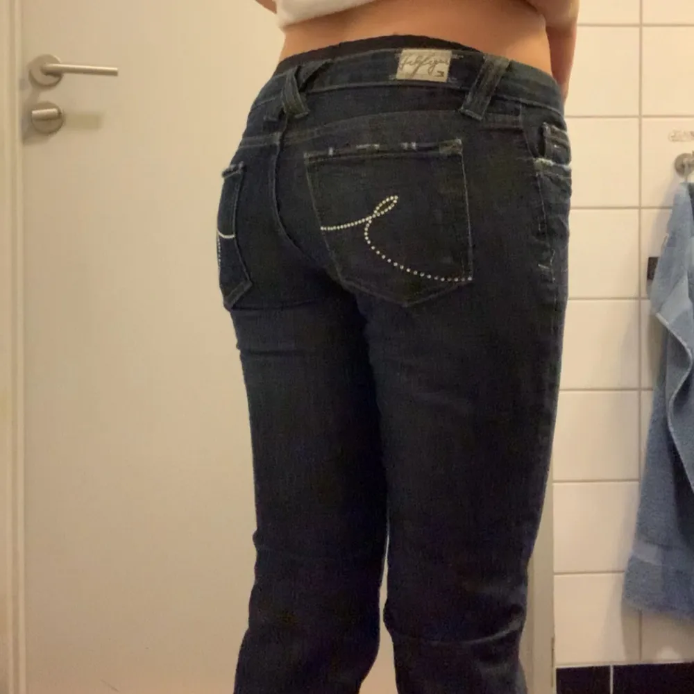 Mörka lågmidjade Tommy Hilfiger jeans som är försmå för mig i midjan vilket syns. Står storlek 27/34 men det stämmer ej. Storlek Xs i midjan och längd 34. Perfekta på mig som är 172cm. Använda men bra skick. Jeans & Byxor.