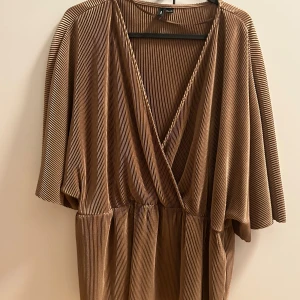 Guldig blus - Guldig blus från Vero Moda med resår i midjan som ger lite peplum effekt.  Använd fåtal gånger, som ny.