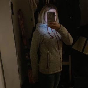 Vinter/ fleece jacka - Aldrig använt när jag väl fått den men den är i perfekt skick och inga skador. En jättefin jacka att ha nu på hösten eller vintern men har valt att sälja den då jag tycker att den inte passar mig❤️ Den är grå med vinröda dragkedjor och detaljer💕