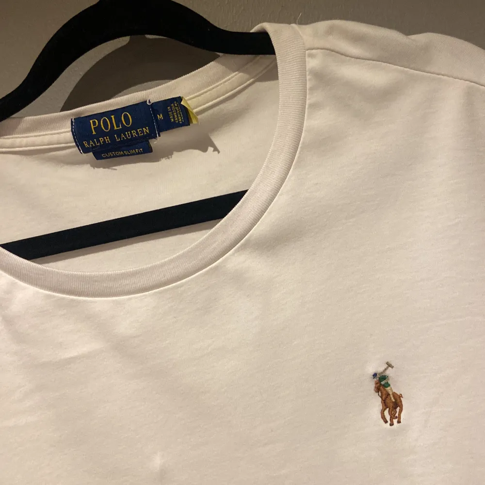 •Ralph Lauren t-shirt vit ”custom slim fit”. Storlek M. Fint skick, väl använd. Inga defekter/skador med plagget! Ända är att det är väl tvättat så qr skann har nötts ut. Men har Äktenhetsbevis och är 100% äkta✅ pris ej hugget i sten! Mvh Oliver. T-shirts.