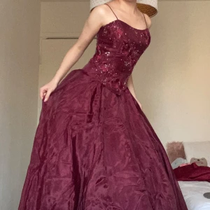balklänning  - Använt endast 1 gång. Extra puffig prinsessa balklänning i vacker burgundy färg med sydda detaljer samt insydd bh. Kjolen består av 5 olika lager. Meddela mig vid frågor eller om fler bilder önskas ❤️