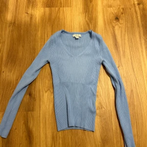 Topp  - En långärmad tröja i en fin blå färg i storlek M. I mycket bra skick. Använt 1 gång! 