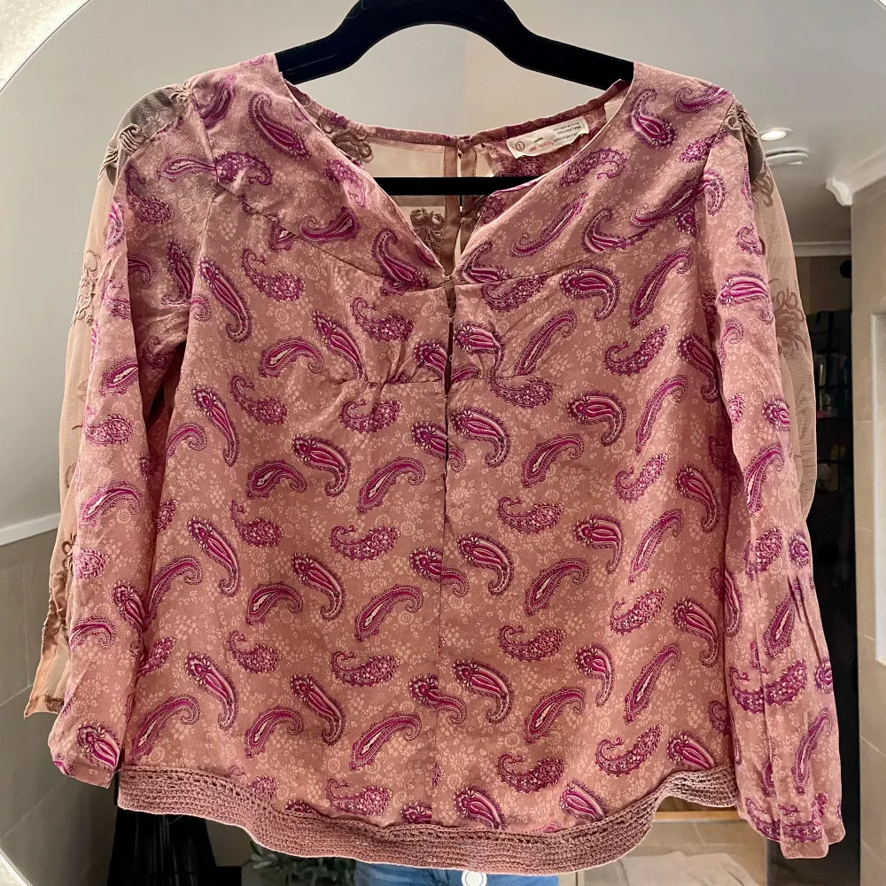 Säljer en superfin rosa blus från Odd Molly med ett snyggt paisleymönster i olika nyanser av rosa och lila. Blusen är gjord av 100% silke och har långa ärmar. Den har en v-ringad design och knappar i ryggen. I fint skick!💕. Toppar.