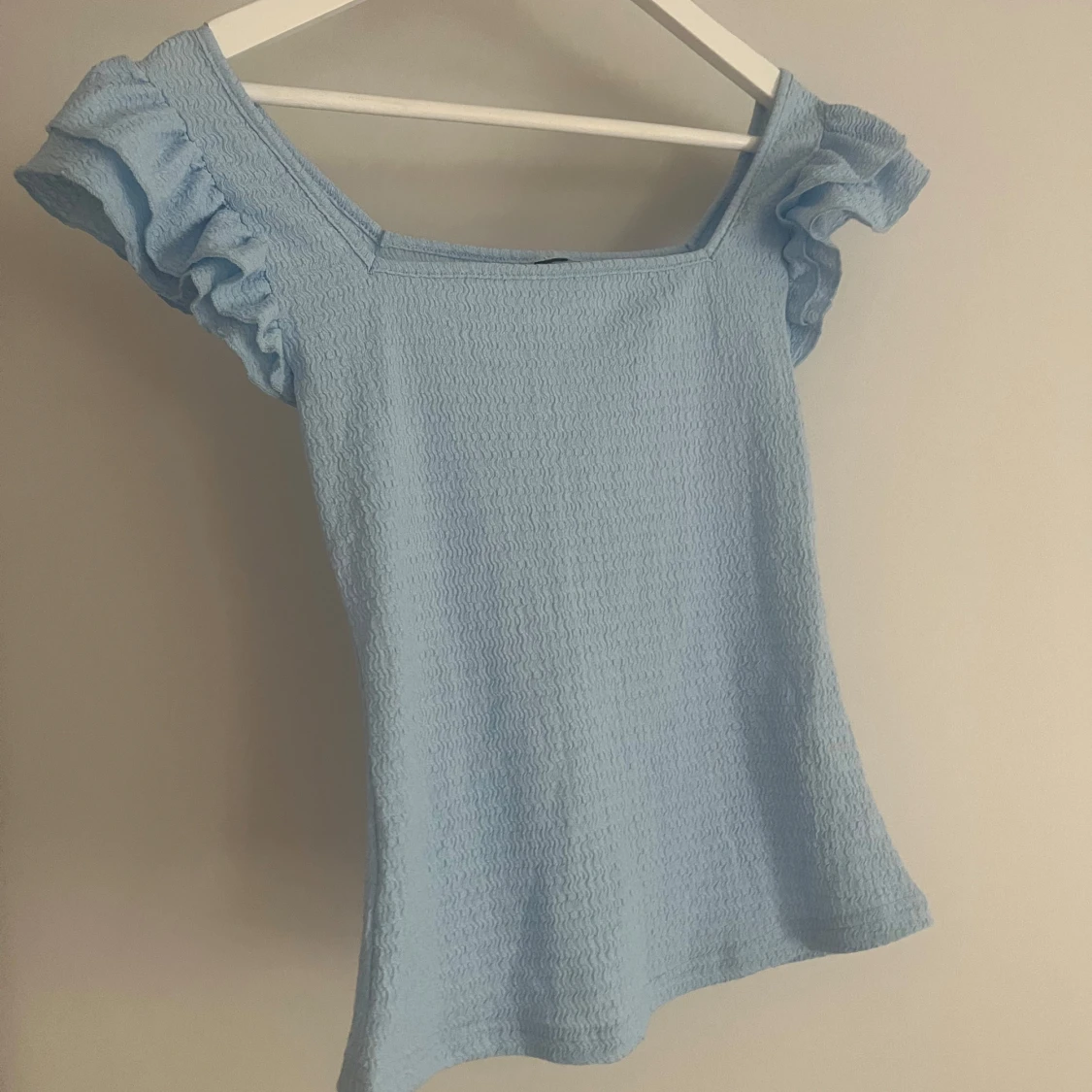 Ljusblå blus med volang 