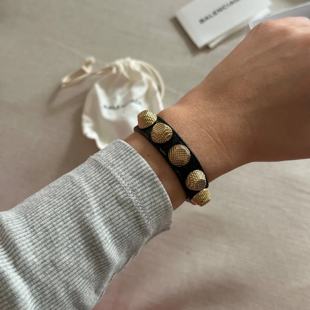 Armband med nitar från Balenciaga. Använd fåtal gånger men det förekommer viss slitage på remmen, se sista bild, annars i jättefint skick!. Accessoarer.