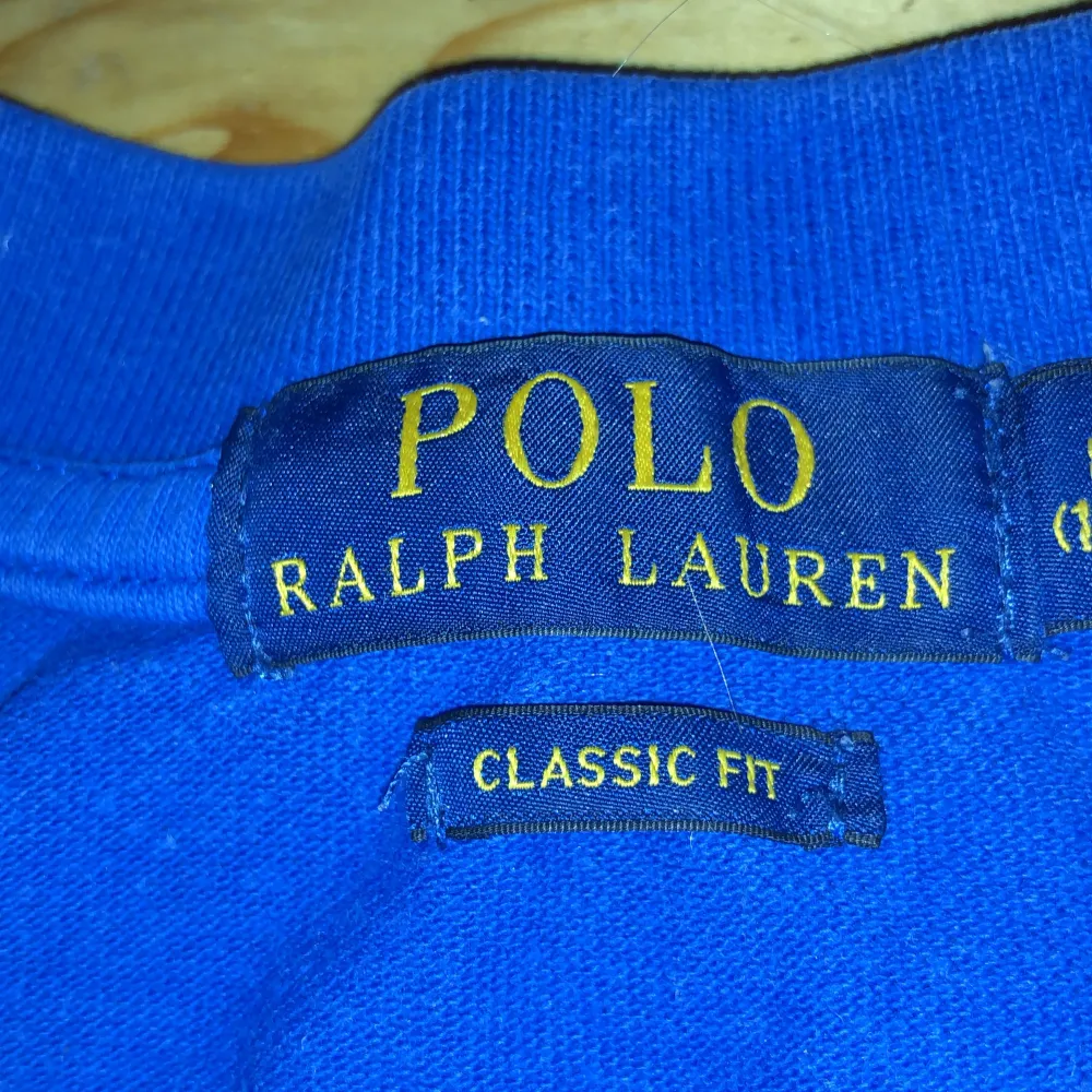 Säljer en snygg blå pikétröja från Ralph Lauren med klassisk passform. Tröjan har korta ärmar och en röd broderad logga på bröstet. Perfekt för en avslappnad men stilren look!. T-shirts.