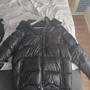 Ralph lauren jacka glossy svart - Säljer min ralph lauren jacka  (9/10 skick) då jag behöver lite pengar. Den är ganska svår att få tag på i den är storleken. Priset är  hugget i sten och kan visa bevis på att jag har köpt den( inga byten)   Mvh David:) 