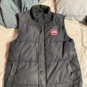 Canada Goose Väst - Säljer västen då ja aldrig använder den. Äkta givetvis men inget kvitto då det tappats bort mellan olika ägare. Ett litet hål på ryggen men inget som märks av. 