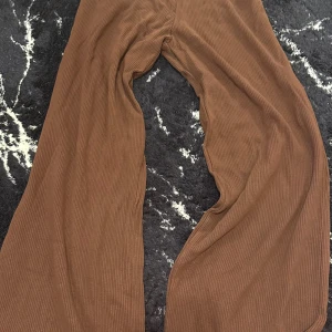 Bruna manchesterbyxor - Säljer ett par snygga bruna manchesterbyxor i loose fit. De är perfekta för höst och vinter med sin mjuka och varma känsla. Byxorna har en hög midja och en bred passform som ger en avslappnad stil. Perfekta för både vardag och chill!