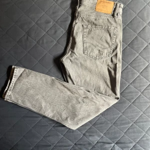 Grå jeans från Jack & Jones (oanvända) - Säljer ett par snygga grå jeans från Jack & Jones i modellen Chris. Storlek 30 i midjan och 32 i längd. Själv är jag 180 och de sitter perfekt. 