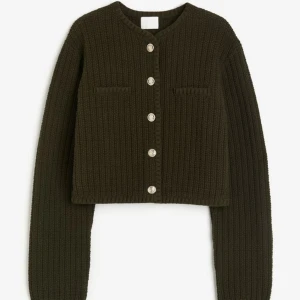 Stickad kofta H&M - Mörkgrön/ olivgrön strukturstickad kofta med guldknappar, helt oanvänd. Dock ett litet igensytt hål vid knapphålet som fanns där när den köptes 