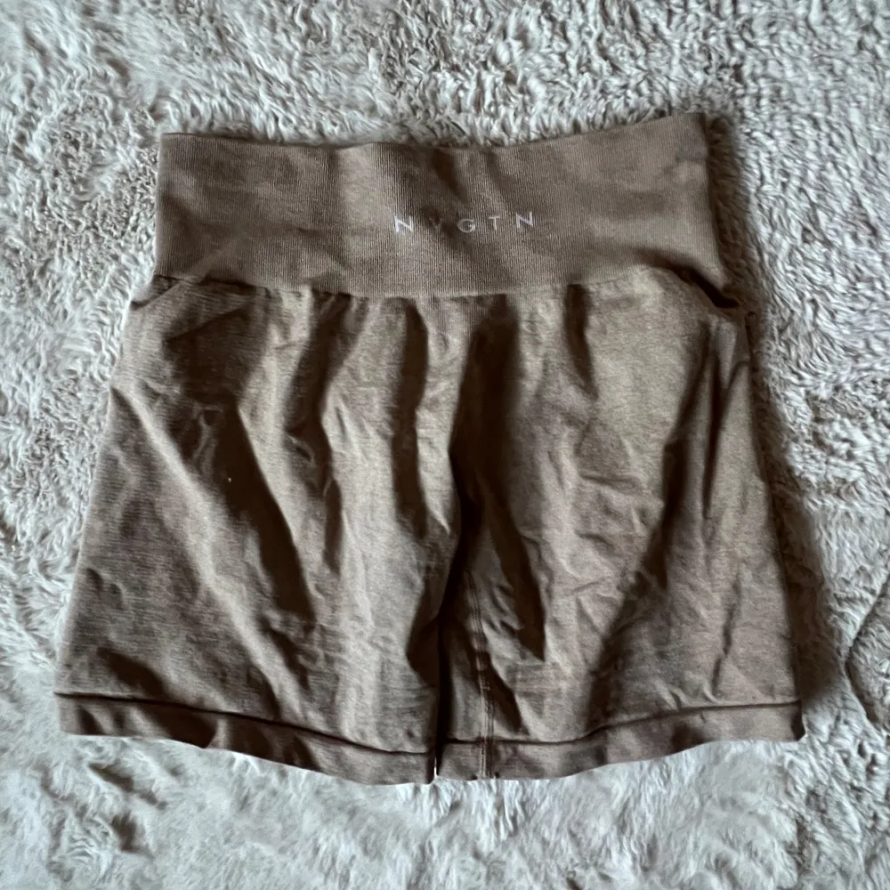 Säljer ett par snygga beige/bruna shorts från NVGTN. Formar sig väldigt bra och är super sköna att ha på sig, mjuka och stretchiga✨ I fint skick, storlek M . Shorts.