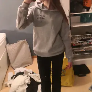 Säljer en grå hoodie från Gina Tricot med texten 'Je m'en amour' och en stjärna tryckt på framsidan. Den är supermjuk och perfekt för en avslappnad stil. Passar bra till både jeans och leggings. Perfekt för höst och vår!💕