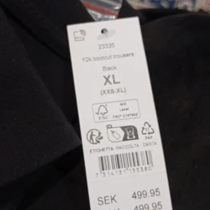 Svarta Y2k bootcut byxor - Säljer ett par svarta Y2k bootcut byxor i storlek XL. De har en snygg och modern bootcut-stil med knappar framtill. Perfekta för både vardag och fest! 🖤