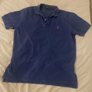 Ralph Lauren piké - Säljer en mörkblå/marinblå Ralph Lauren piké med en röd logga i stl L och den är i ett hyfsat bra skick, använd som sagt. Skriv till mig vid frågor, pris kan diskuteras! 🤝👕