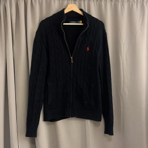 Svart kofta från Polo Ralph Lauren - Säljer en snygg svart kofta från Polo Ralph Lauren i storlek M men sitter även mindre, den är i sjukt bra skick passar mellan 175-183 och 60-70kg!