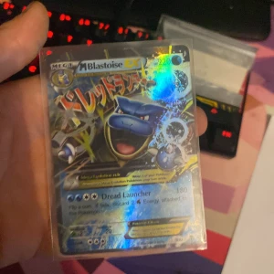 M Blastoise EX Pokémonkort - Säljer ett M Blastoise EX Pokémonkort med en cool holografisk design.  Kortet är en del av Mega Evolution-serien från 2016. Perfekt för samlare eller Pokémon TCG-spelare som vill förstärka sin kortlek med en kraftfull vatten-Pokémon. Ny pris 1000 kr på ebay.