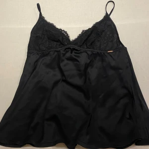 Svart satinlinne med spetsdetaljer - Så snygg satin topp som är bar i ryggen med knyte. Så så snygg men tyvärr för liten för mig som är 70C i kupan. Skulle säga att kupa B och neråt passar denna