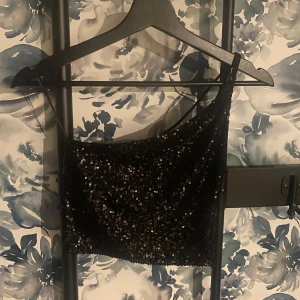Svart paljettprydd oneshoulder topp - Snygg svart topp med paljetter, aldrig använd men prislapp borttagen!